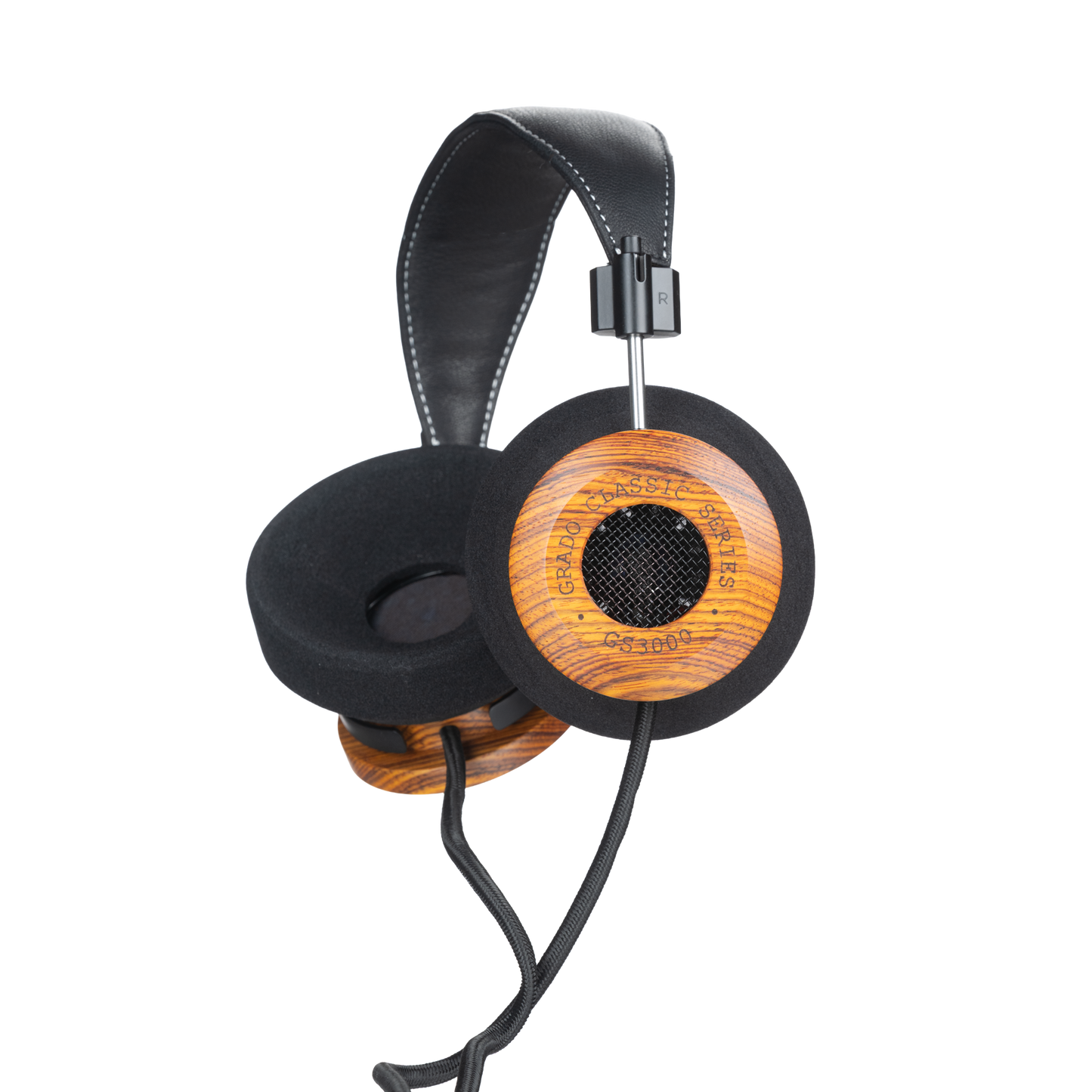 Photo of Grado GS3000 Headphones on a white background taken from the 3/4 view - One ear cup is facing down while the other ear cup is facing outward - the words - Grado Classic Series - and - GS3000 - can be seen on the ear cup.