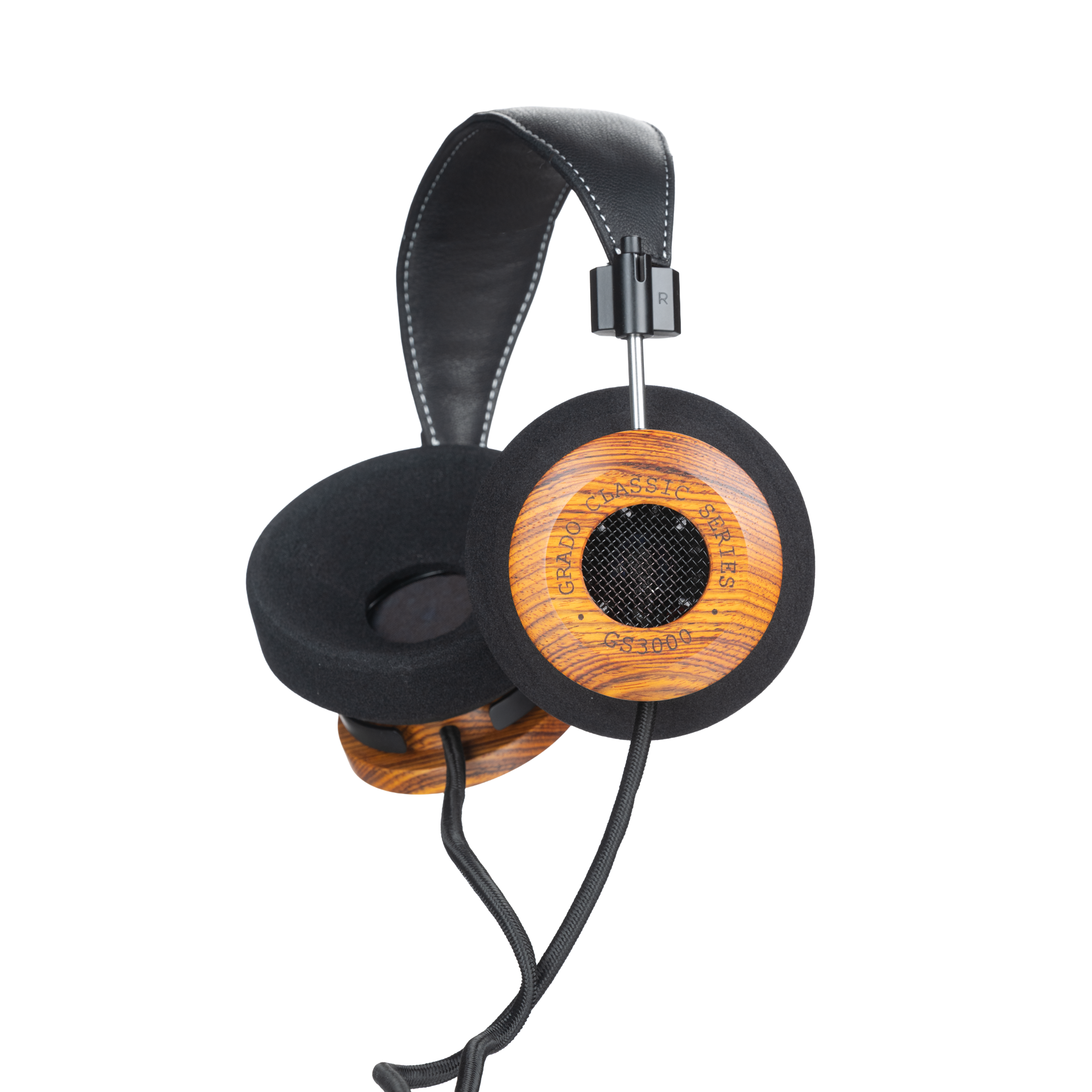 Photo of Grado GS3000 Headphones on a white background taken from the 3/4 view - One ear cup is facing down while the other ear cup is facing outward - the words - Grado Classic Series - and - GS3000 - can be seen on the ear cup.