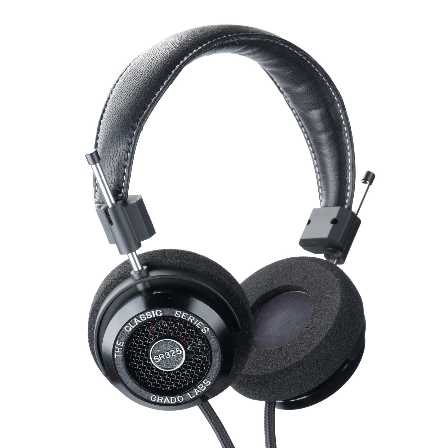 Photo of Grado SR325 Headphones  taken from 3/4 view - one ear cup is facing away from view while the other is showing the model name - SR325 - can be seen in the center and the words - The Classic Series - and - Grado Labs are written on the outside edge of the ear cups. The cables can be seen coming out of the headphone.