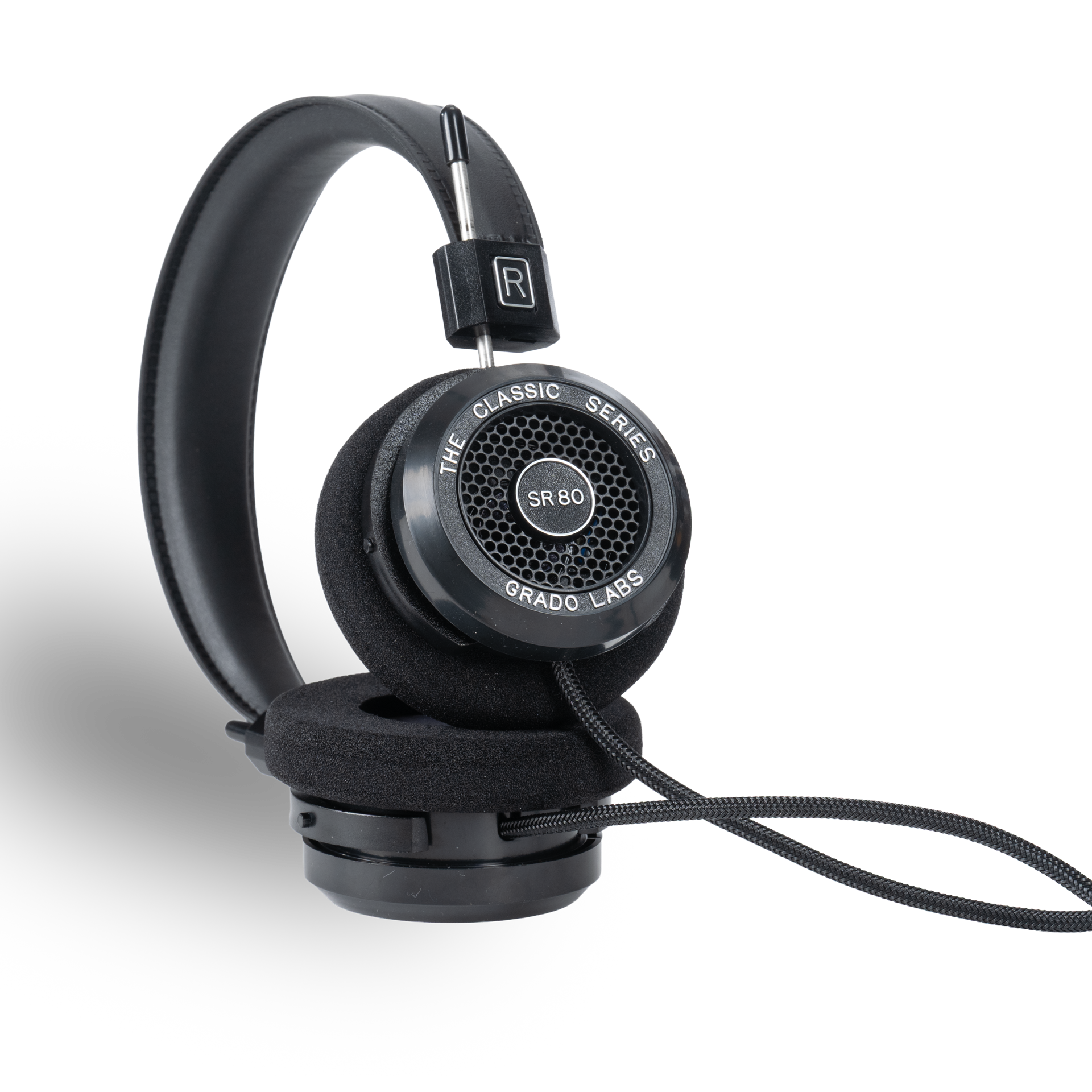 Photo of Grado SR80 Headphones taken from the 3/4 view - One ear cup is facing down while the other ear cup is facing outward - showing the model name in the center - SR80 - and the words - The Classic Series - and - Grado Labs - written along the edge of the ear cups.