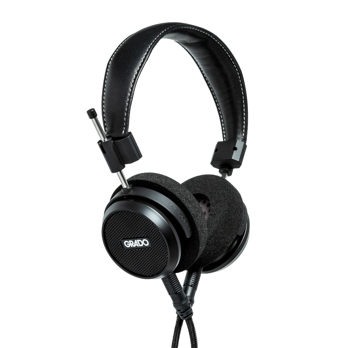 Photo of Grado S150 Headphones taken from the 3/4 view - the Grado logo is featured in the center of the ear cup and the black cables can be seen coming out of the headphone.