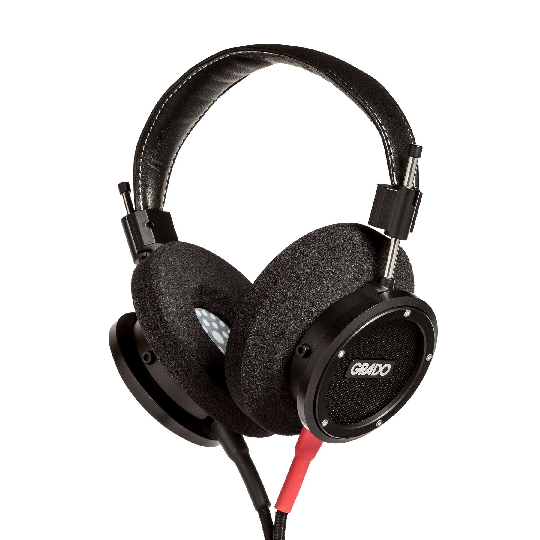 Photo of Grado S750 Headphones on a white background taken from 3/4 view - one ear cup is facing away from view while the other is showing the Grado logo in the center. The red/black cables can be seen coming out of the headphone.