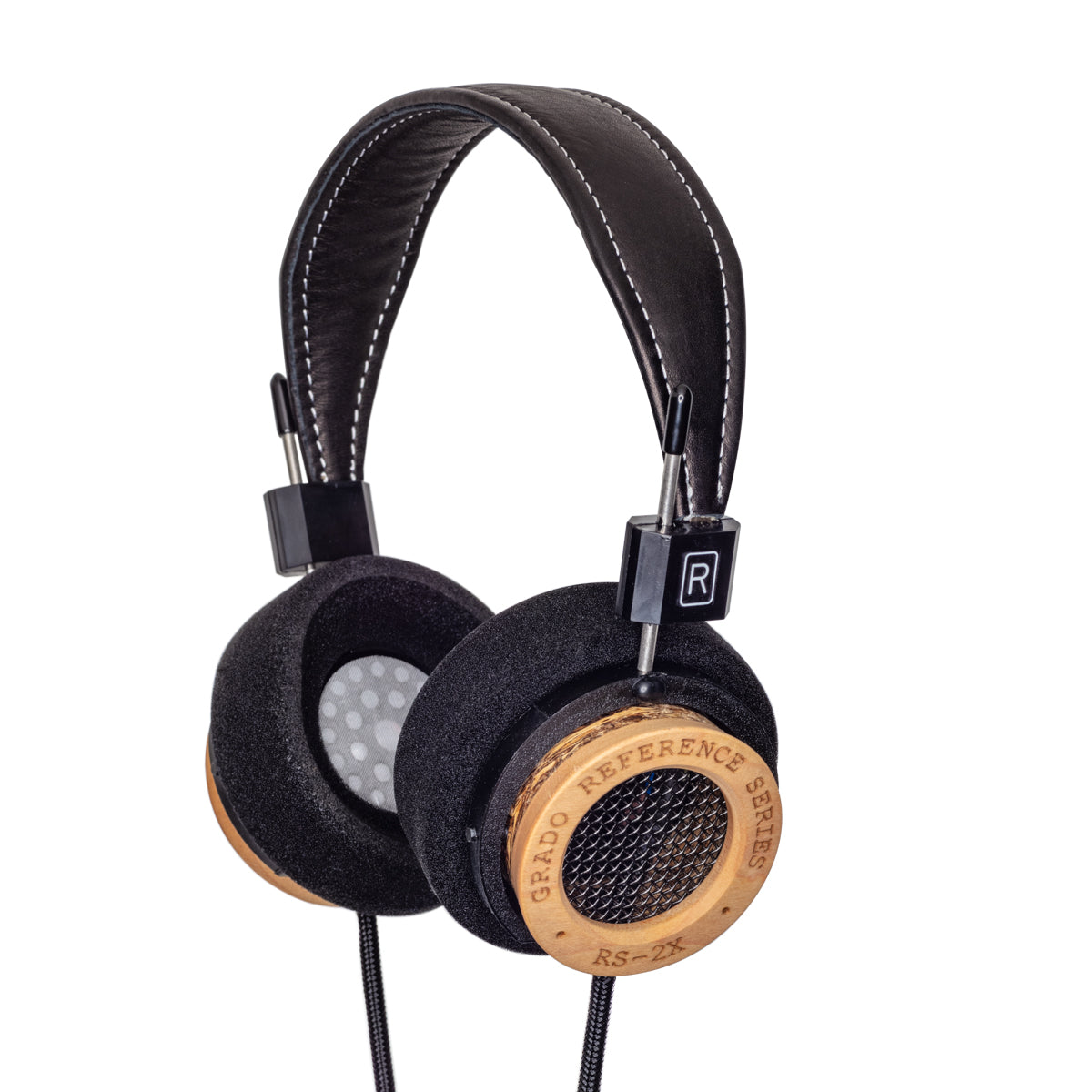 Photo of Grado RS2x Headphones  taken from 3/4 view - one ear cup is facing away from view while the other is showing the model name - 'RS2x' - and the words - 'The Reference Series'  are written on the outside edge of the ear cups. The cables can be seen coming out of the headphone.