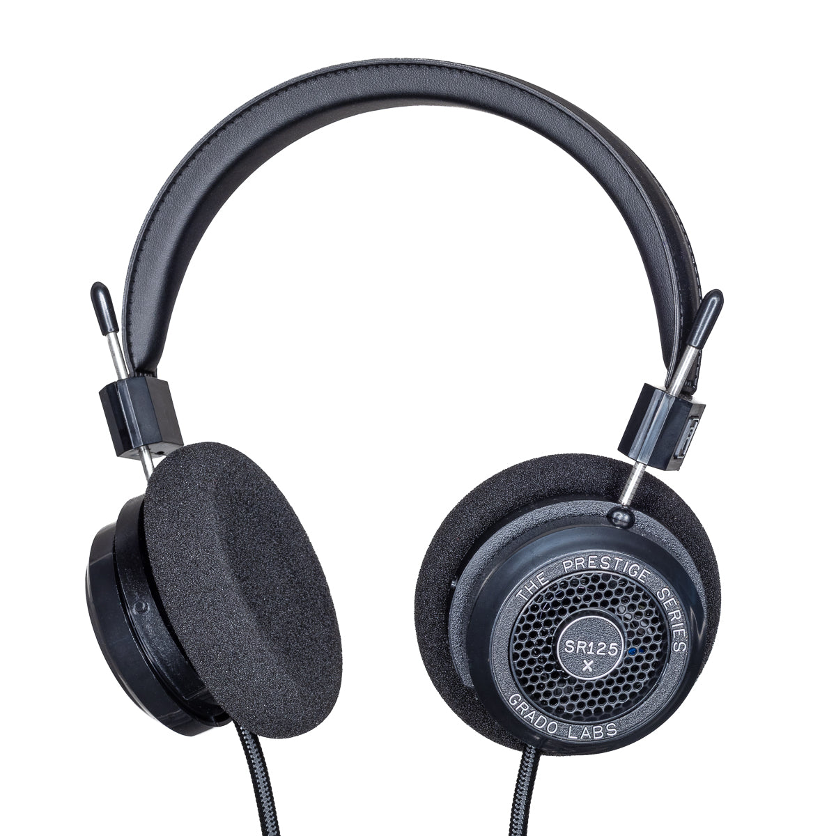 Photo of Grado SR125x Headphones  taken from 3/4 view - one ear cup is facing away from view while the other is showing the model name - SR125x - can be seen in the center and the words - The Prestige Series - and - Grado Labs are written on the outside edge of the ear cups. The cables can be seen coming out of the headphone.